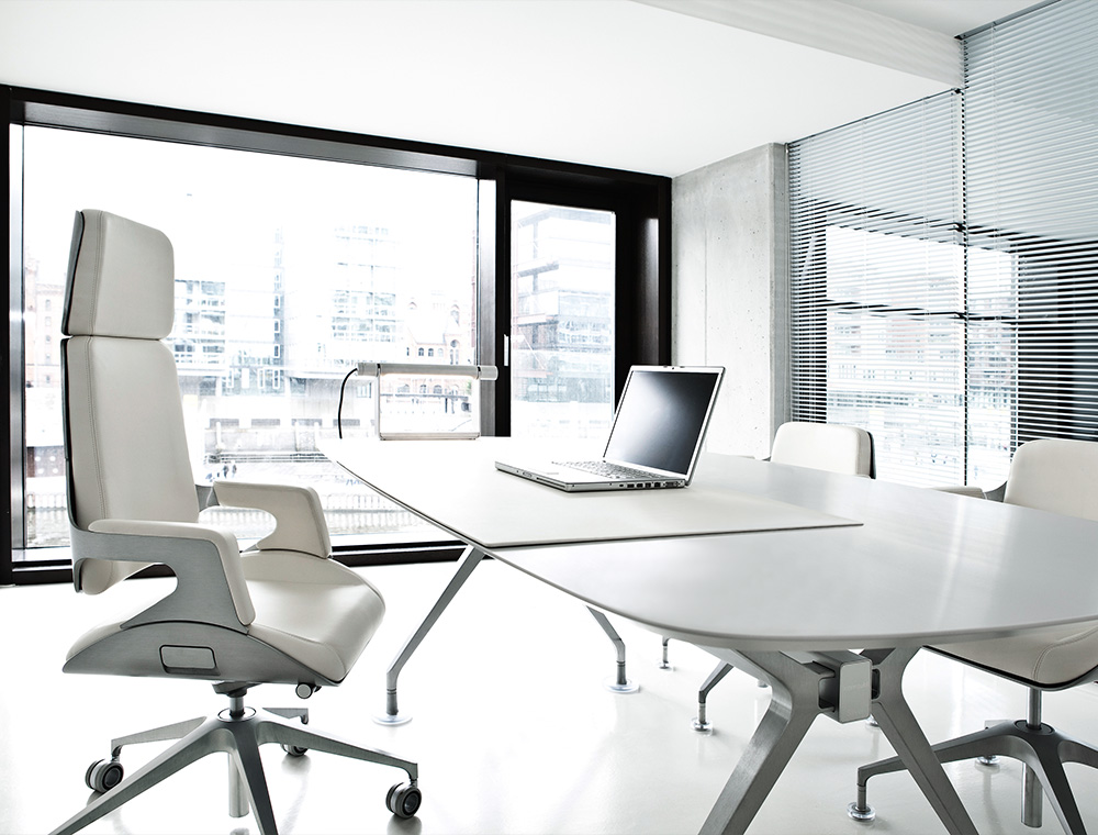 Et udsnit af et kontor med to SILVER-kontorstole af høj kvalitet ved skriveborde over for hinanden og et rundt bord med flere SILVER-konferencestole.