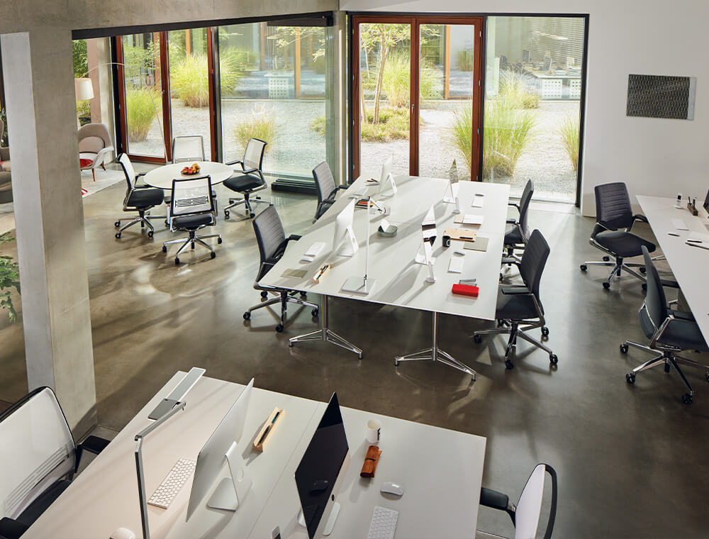 Een open kantoor met moderne VINTAGE-bureaustoelen met stoffen bekleding en netbespanning.