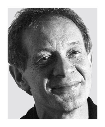 Zwart-wit portret van de ontwerper Hans-Georg Piorek, die met een glimlach richting camera kijkt