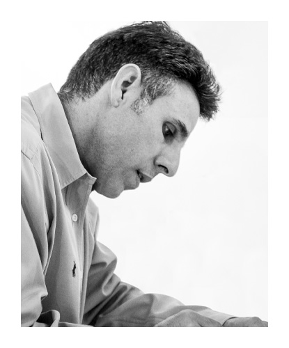Portrait en noir et blanc du designer Daniel Figueroa, assis et concentré sur son travail