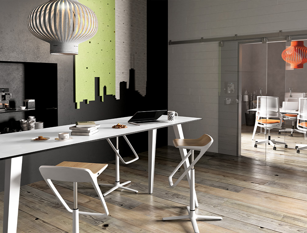 Three stylish KINETIC bar stools with a white base frame and wooden seat surface stand around a standing table in white in a lounge area of the office.