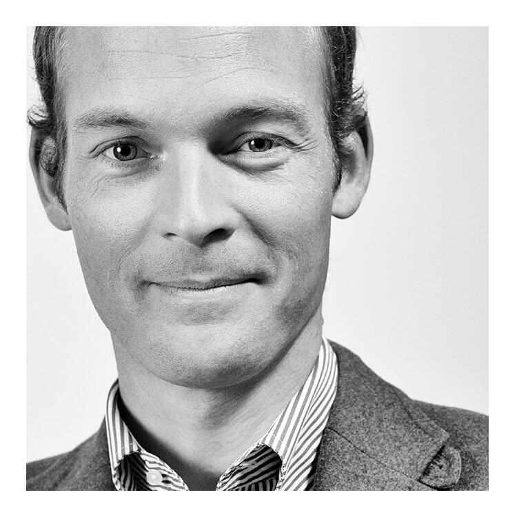 Retrato en blanco y negro de Sven von Boetticher, diseñador del modelo EVERY. Sonríe a la cámara con camisa y chaqueta.
