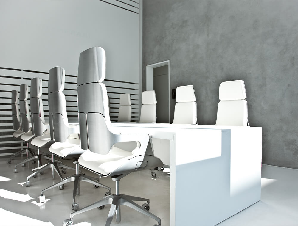 A conference room with ten high SILVER executive chairs with white leather cover at a long white table.