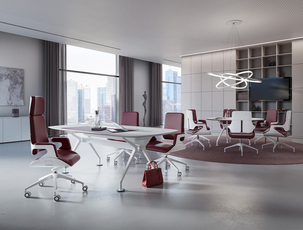 A large office with a high SILVER swivel chair with Bordeaux-red leather cover with two conference chairs opposite. There is a round table with further high-quality swivel chairs in the background.